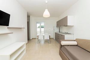a kitchen and living room with a couch and a table at Ungaretti Resort in Porto Cesareo