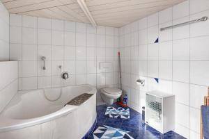 a bathroom with a tub and a toilet at Bachbubenhof in Hüfingen +42 photos