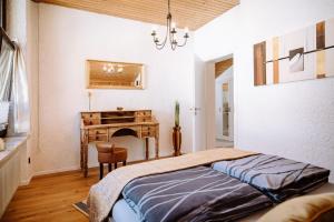 a bedroom with a bed and a table and a desk at Ferienwohnung Seeidyll am Wörthsee in Wörthsee