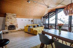 a living room with a yellow couch and a fireplace at Ferienwohnung Seeidyll am Wörthsee in Wörthsee