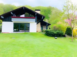 a house with a green yard in front of it at Ferienwohnung Seeidyll am Wörthsee in Wörthsee