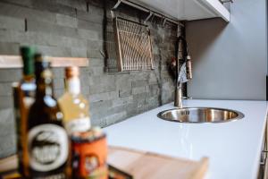 a kitchen counter with a sink and some bottles at Ferienwohnung Seeidyll am Wörthsee in Wörthsee +35 photos