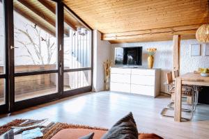 a living room with a large window and a television at Ferienwohnung Seeidyll am Wörthsee in Wörthsee