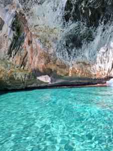 a body of water next to a rocky cliff at Home Garden in Cala Gonone