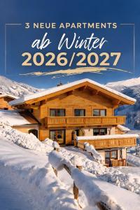 a log home in the snow with the words new apartments ak winter at Haus Kropfa in Hippach