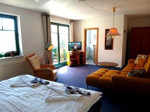 a bedroom with a bed and a couch and a tv at Gästehaus Knuth Zinnowitz in Zinnowitz