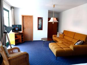 a living room with a couch and a tv at Gästehaus Knuth Zinnowitz in Zinnowitz +25 photos