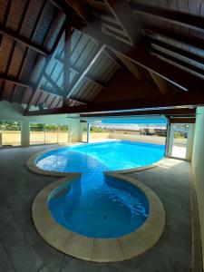 a large swimming pool with blue water in a building at A 208 Pics D'aran in Luchon