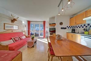 a living room with a red couch and a wooden table at A 208 Pics D'aran in Luchon