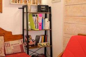 a book shelf with books and a tv on it at A 208 Pics D'aran in Luchon