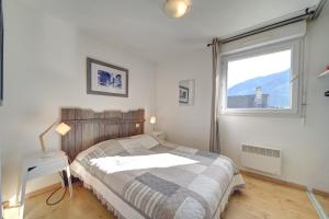 a bedroom with a large bed and a window at A 208 Pics D'aran in Luchon +20 photos