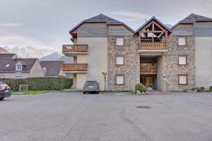 a large brick building with a car parked in a parking lot at A 208 Pics D'aran in Luchon