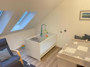 a baby room with a crib and a table at Ferienwohnung Ankerleicht in Steinbergkirche