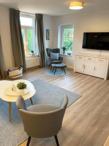 a living room with a television and a table and chairs at Ferienwohnung Ankerleicht in Steinbergkirche