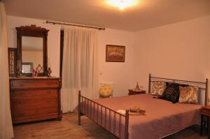 a bedroom with a bed with a dresser and a mirror at House For Rent In Apostolous in Apóstoloi