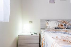 a bedroom with a bed and a night stand at Dimora Frau in Villasimius +18 photos