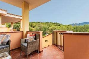 a balcony with chairs and a view of the mountains at Dimora Frau in Villasimius