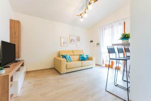 a living room with a couch and a television at Dimora Frau in Villasimius