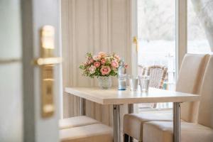 a table with a vase of flowers on it at Villa Gruner Nr 13 in Zinnowitz +17 photos