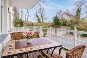 a balcony with a table with a vase of flowers at Villa Gruner Nr 13 in Zinnowitz