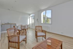 a living room with a table and chairs and a table and a table at Maisons de Saint Guenolé in Batz-sur-Mer