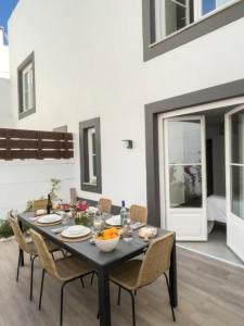 a dining room with a black table and chairs at Jasmine House in Tavira