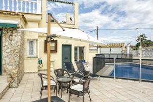 a patio with a table and chairs and a pool at Villa Empuries A2 in Empuriabrava