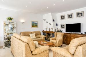 a living room with couches and a flat screen tv at Villa Empuries A2 in Empuriabrava