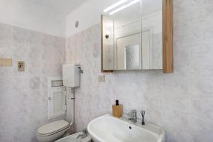a bathroom with a sink and a toilet and a mirror at Casa Leah in Imperia +13 photos