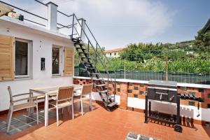 a patio with a wooden table and a fire grill at Casa Leah in Imperia