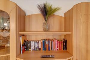 a book shelf with a vase filled with books at Im Grünen in Weil der Stadt