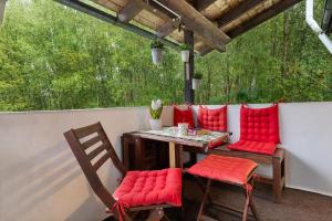 a table and chairs with red cushions on a patio at Im Grünen in Weil der Stadt