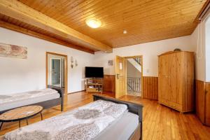 a living room with two beds and a tv at Restaurant Fewo Golsong in Thaleischweiler-Fröschen