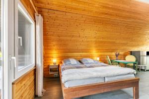 a bedroom with a wooden wall with a bed at Holzhaus am Waldrand in Niederfinow