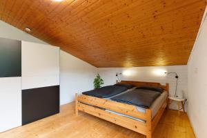 a bed in a room with a wooden ceiling at Ferienhaus Schwarzwaldleben in Seebach
