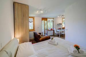 a bedroom with a white bed and a living room at Studio La Borracina Mountain View - Happy Rentals in Sauze dʼOulx