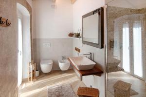 a white bathroom with a sink and a mirror at Thari House Como Lake in Naggio +25 photos