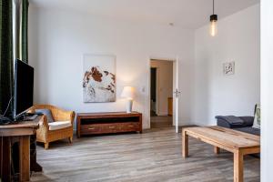 a living room with a couch and a table and a desk at Ferienwohnung Flut am Weserstrand in Sandstedt