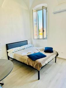 a bedroom with a bed with blue pillows and a table at Domus Madonnina in Sanremo