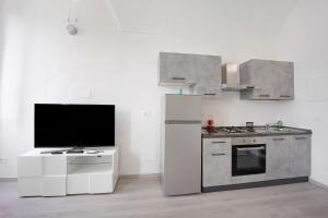a kitchen with a refrigerator and a tv in it at Domus Madonnina in Sanremo