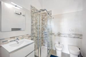 a white bathroom with a sink and a toilet at Domus Madonnina in Sanremo +13 photos