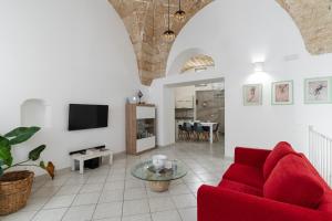 a living room with a red couch and a tv at Civico4 luxuryholidays in Casarano