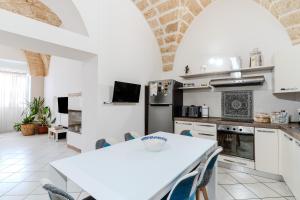 a kitchen with white appliances and a table with chairs at Civico4 luxuryholidays in Casarano