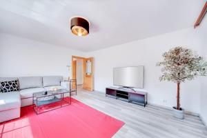 a living room with a couch and a tv at Ferienwohnung Seenähe in Mattsee