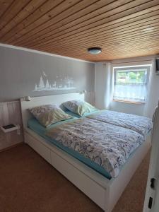 a bed in a room with a wooden ceiling at Ferienwohnung Kleiner Spatz in Leutkirch im Allgäu