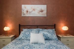 a bedroom with a bed with blue and white pillows at Villa Simona con giardino in Favara