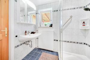 a white bathroom with a sink and a shower at Ferienwohnung Seenähe in Mattsee +16 photos