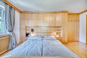a bed in a room with wooden walls and a window at Ferienwohnung Seenähe in Mattsee