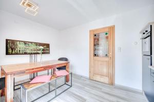 a dining room with a wooden table and a kitchen at Ferienwohnung Seenähe in Mattsee