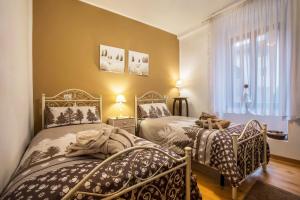 a bedroom with two beds and a window at Appartamento Collini in Spiazzo
